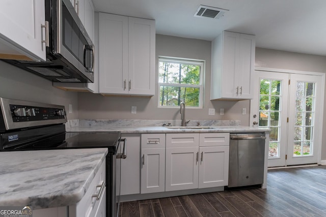 kitchen with sink, white cabinets, stainless steel appliances, and dark hardwood / wood-style flooring