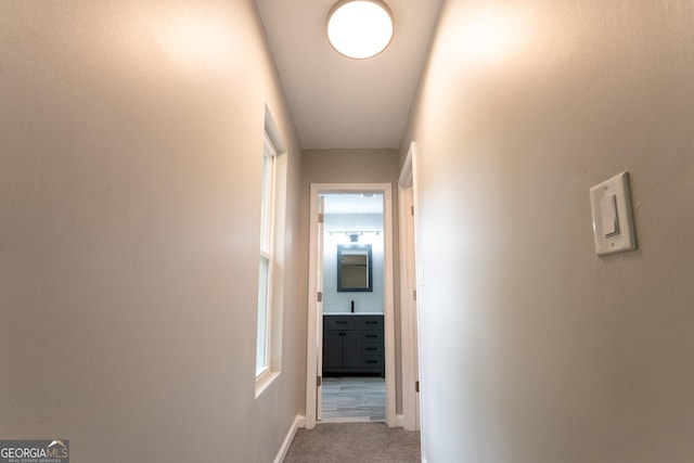 corridor featuring light colored carpet