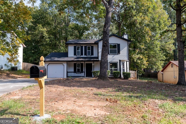 view of front property featuring a porch, a garage, and a storage shed