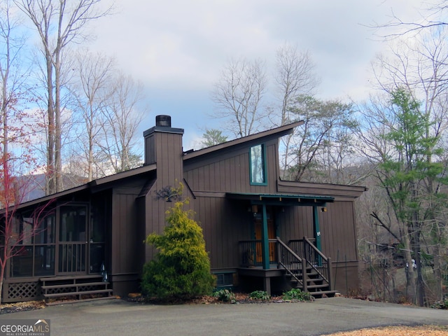 view of front of home with a sunroom and a chimney