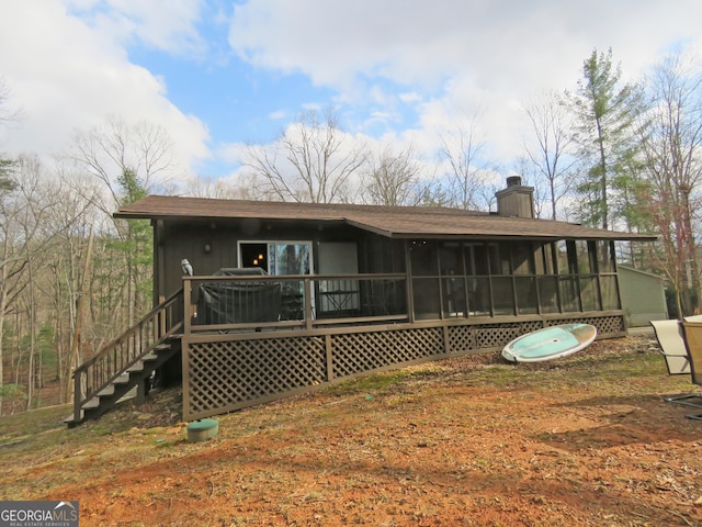 back of house with stairs, a chimney, and a sunroom