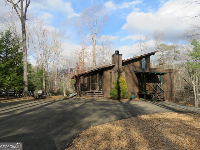 exterior space featuring a chimney and a sunroom