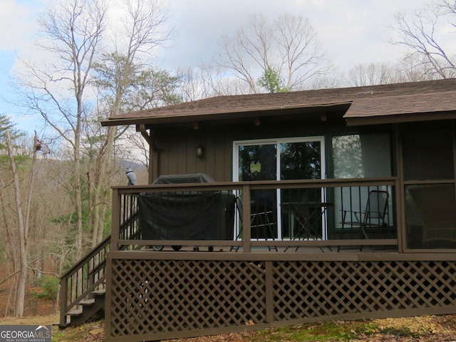 back of house featuring a shingled roof and board and batten siding