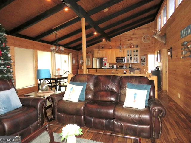 living room featuring a notable chandelier, beamed ceiling, wood finished floors, and wooden walls