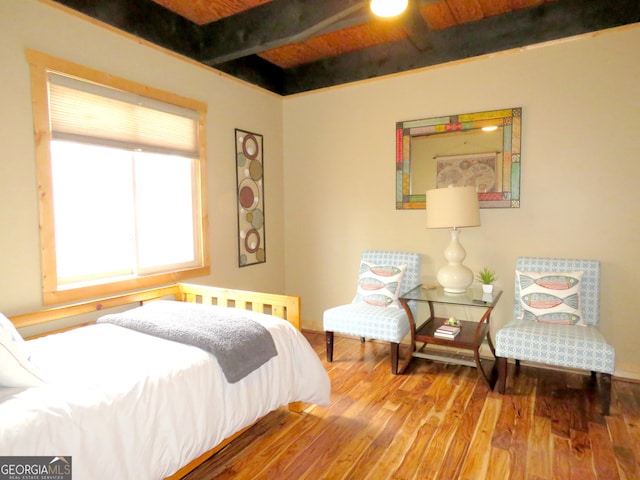 bedroom with beamed ceiling, wood finished floors, and wood ceiling