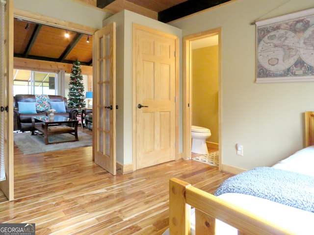 bedroom featuring vaulted ceiling with beams, wooden ceiling, wood finished floors, and baseboards