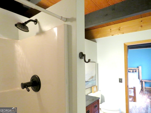 full bathroom featuring a shower, beamed ceiling, and toilet