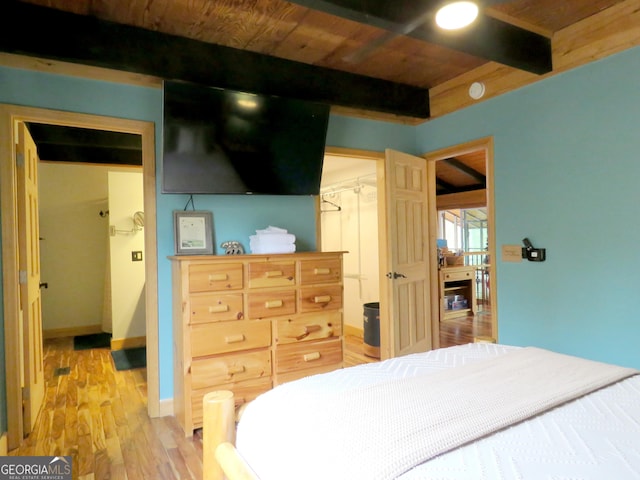 bedroom with light wood finished floors, baseboards, wooden ceiling, beamed ceiling, and a closet