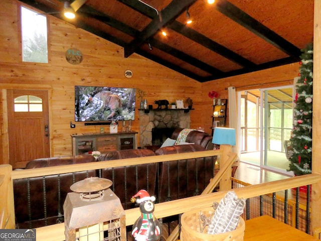 living room featuring a wealth of natural light, wood walls, and lofted ceiling with beams