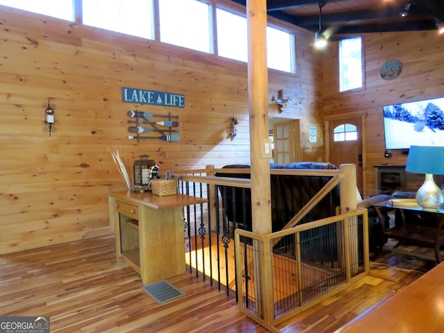 interior space featuring wood walls, a high ceiling, and wood finished floors