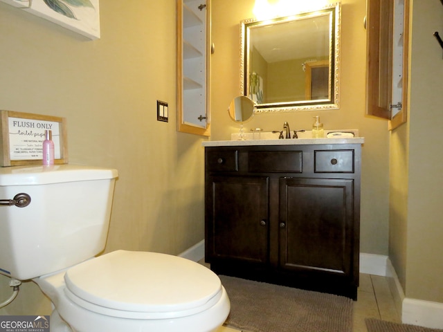 half bathroom with toilet, tile patterned flooring, baseboards, and vanity