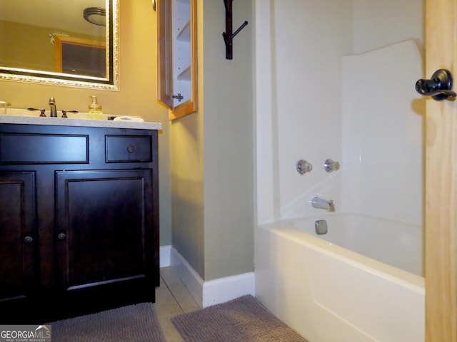 bathroom with  shower combination, vanity, baseboards, and tile patterned floors