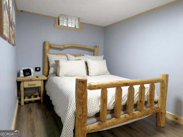 bedroom featuring wood finished floors and baseboards