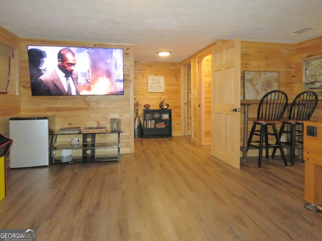 cinema with visible vents, wood walls, and wood finished floors