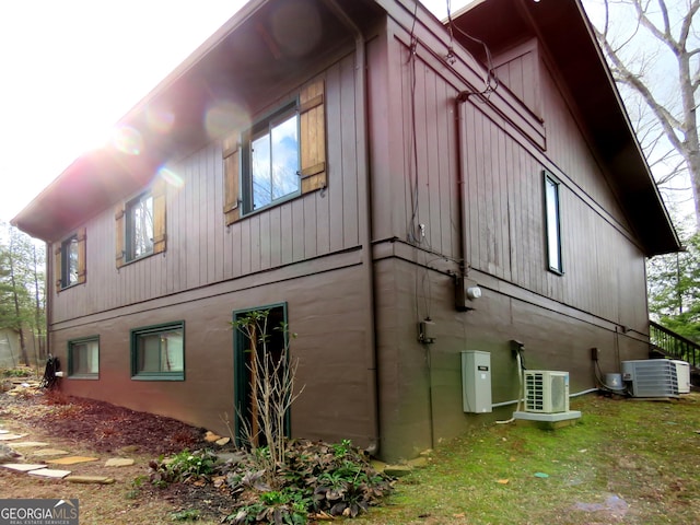 view of side of home with ac unit and cooling unit