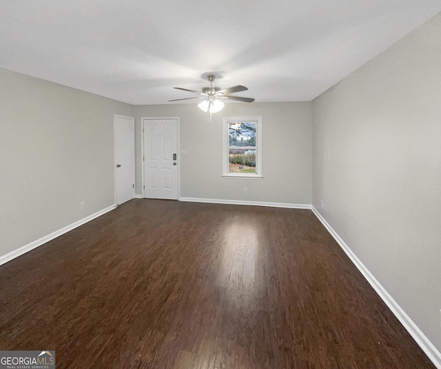 interior space with a ceiling fan, dark wood finished floors, and baseboards