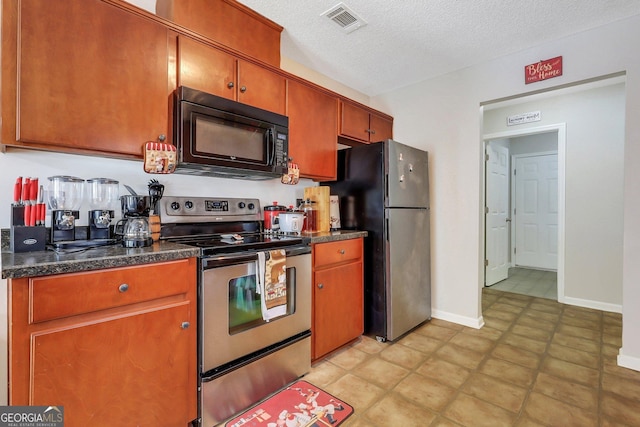 kitchen with appliances with stainless steel finishes and a textured ceiling