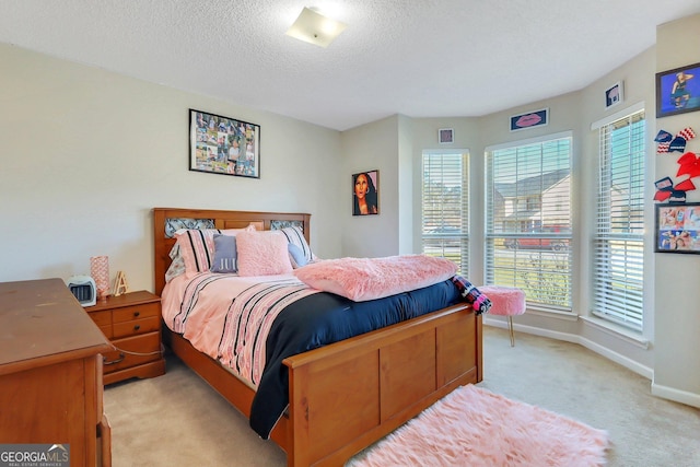 bedroom featuring a textured ceiling and light colored carpet