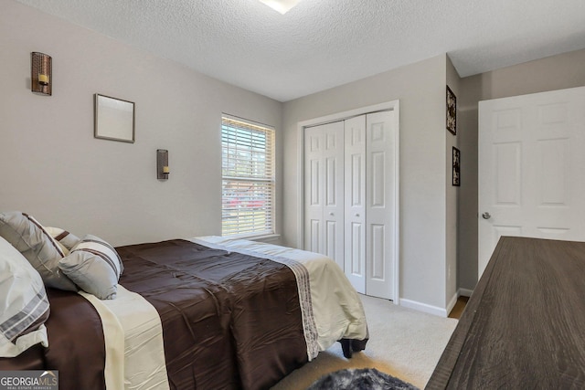 bedroom featuring a textured ceiling, a closet, and light colored carpet