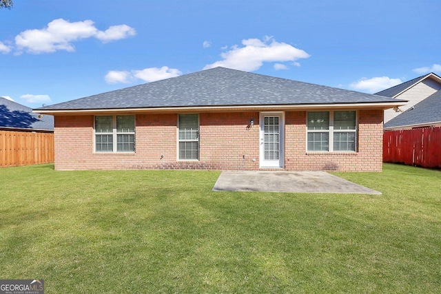 rear view of property featuring a yard and a patio area