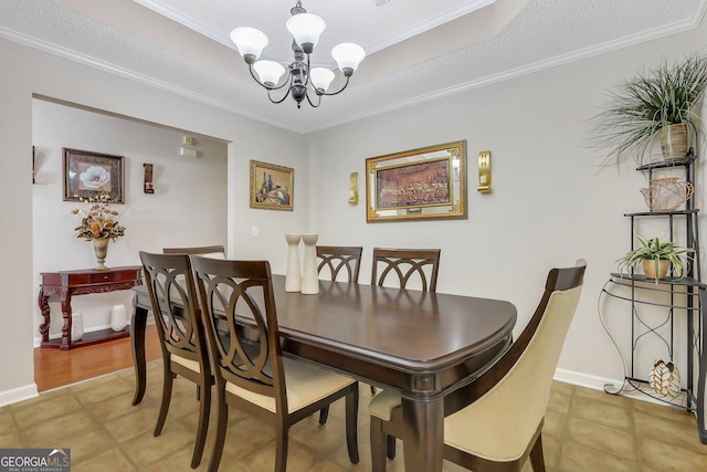 dining room featuring a tray ceiling, a notable chandelier, and ornamental molding