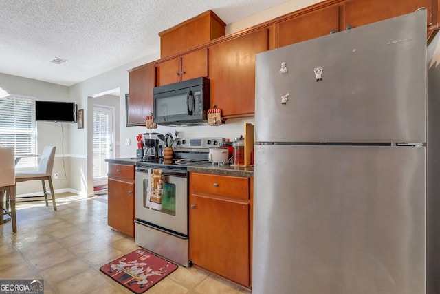 kitchen featuring stainless steel appliances and a textured ceiling