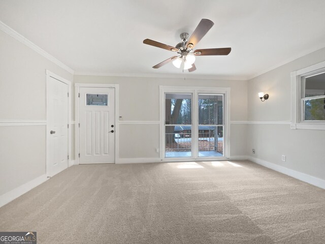 interior space with carpet, crown molding, baseboards, and ceiling fan