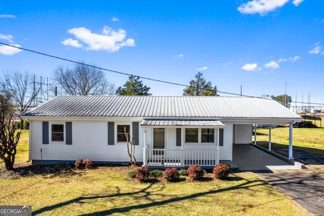 single story home with covered porch, a front lawn, and a carport