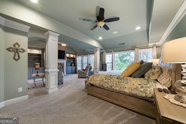 bedroom with a fireplace, carpet floors, ornamental molding, ornate columns, and vaulted ceiling