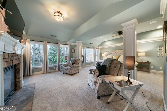 carpeted living room featuring decorative columns, ceiling fan, lofted ceiling, and a stone fireplace