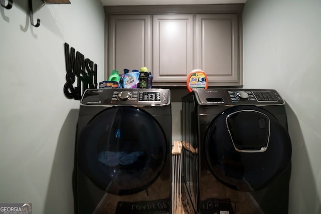 laundry room with washing machine and dryer and cabinets