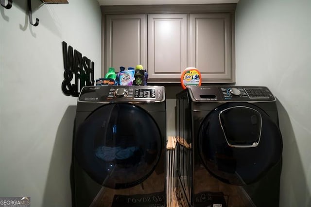 washroom with cabinets and washing machine and dryer