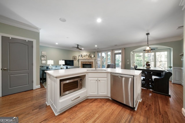 kitchen featuring stainless steel appliances, white cabinetry, and an island with sink