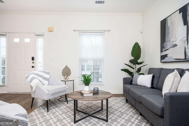 living room with hardwood / wood-style flooring, ornamental molding, and plenty of natural light