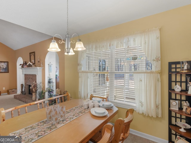 509 Carleton Pl, Locust Grove, GA 30248 - tiled dining area featuring arched walkways, a fireplace, baseboards, a chandelier, and vaulted ceiling