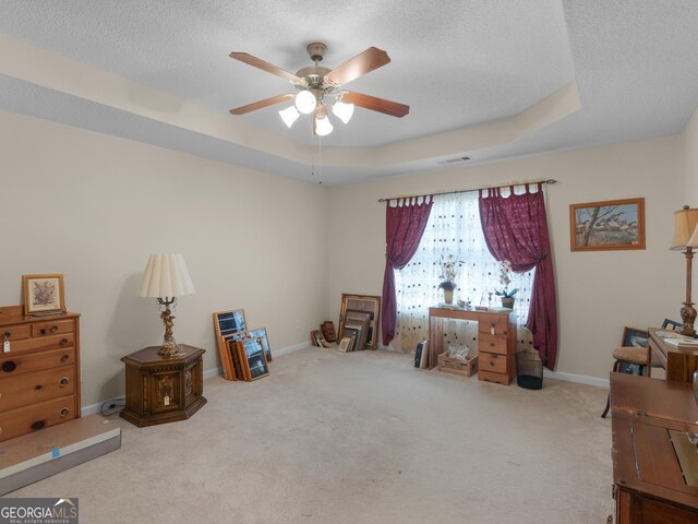 509 Carleton Pl, Locust Grove, GA 30248 - living area featuring a ceiling fan, carpet flooring, a textured ceiling, baseboards, and a tray ceiling