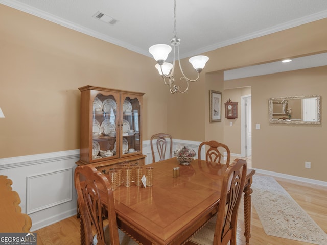 509 Carleton Pl, Locust Grove, GA 30248 - dining room featuring crown molding, a chandelier, a wainscoted wall, and light wood-style flooring