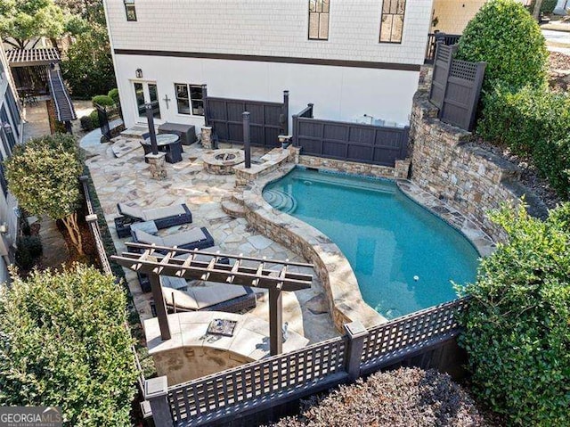 view of swimming pool featuring a patio and a fire pit