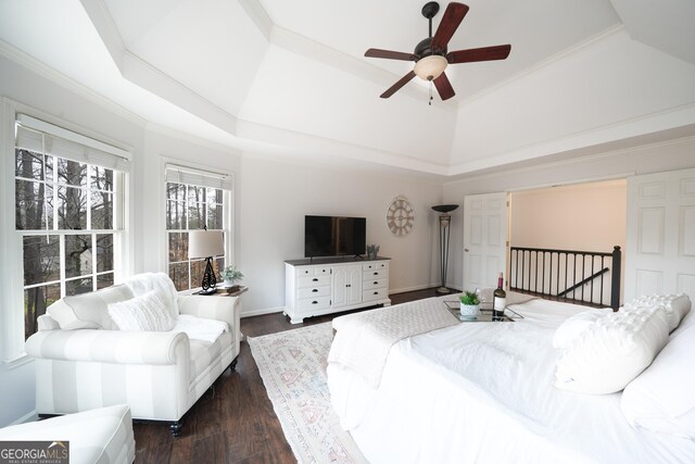 bedroom with ornamental molding, dark wood-style flooring, and a raised ceiling