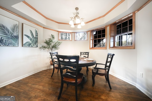 dining room featuring baseboards, dark wood-type flooring, a tray ceiling, crown molding, and a chandelier