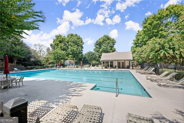 community pool with fence and a patio