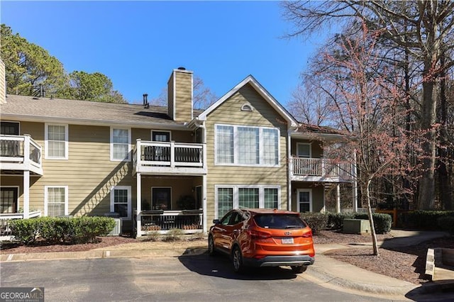 709 Berkeley Woods Unit 709, Duluth, GA 30096 - rear view of house featuring a chimney and a balcony