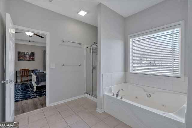 full bath featuring a stall shower, tile patterned flooring, baseboards, and a tub with jets