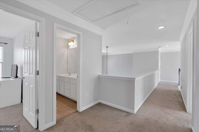 corridor with attic access, ornamental molding, light carpet, an upstairs landing, and baseboards