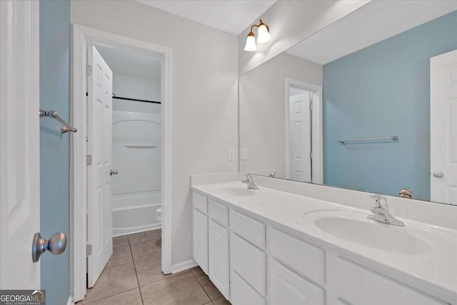 bathroom with toilet, tile patterned flooring, double vanity, and a sink