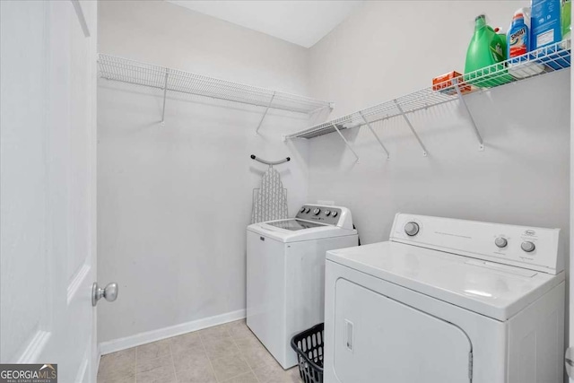 laundry area with laundry area, baseboards, and washer and clothes dryer