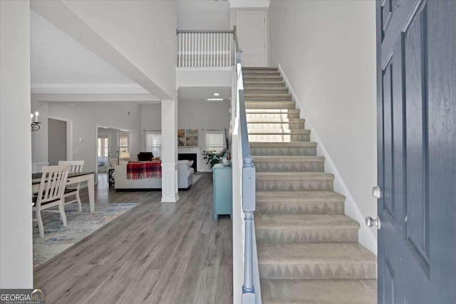 foyer featuring baseboards, stairway, a towering ceiling, and wood finished floors