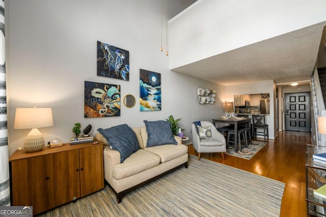 living room with hardwood / wood-style floors and a high ceiling