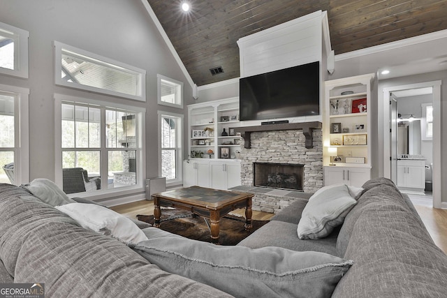 living room featuring light hardwood / wood-style floors, wooden ceiling, built in features, and a fireplace