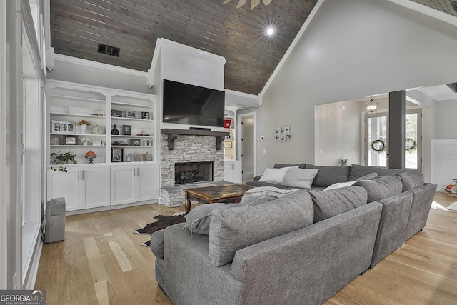 living room featuring a stone fireplace, light hardwood / wood-style floors, wooden ceiling, high vaulted ceiling, and crown molding